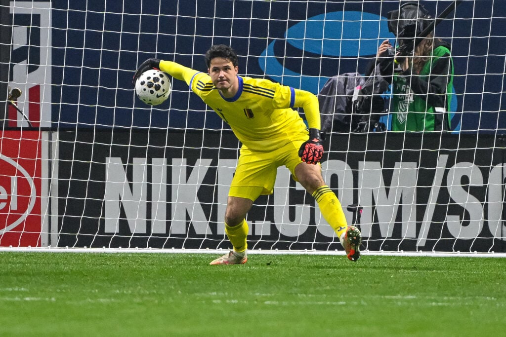 Senne Lammens throws ball out in yellow Belgium kit.