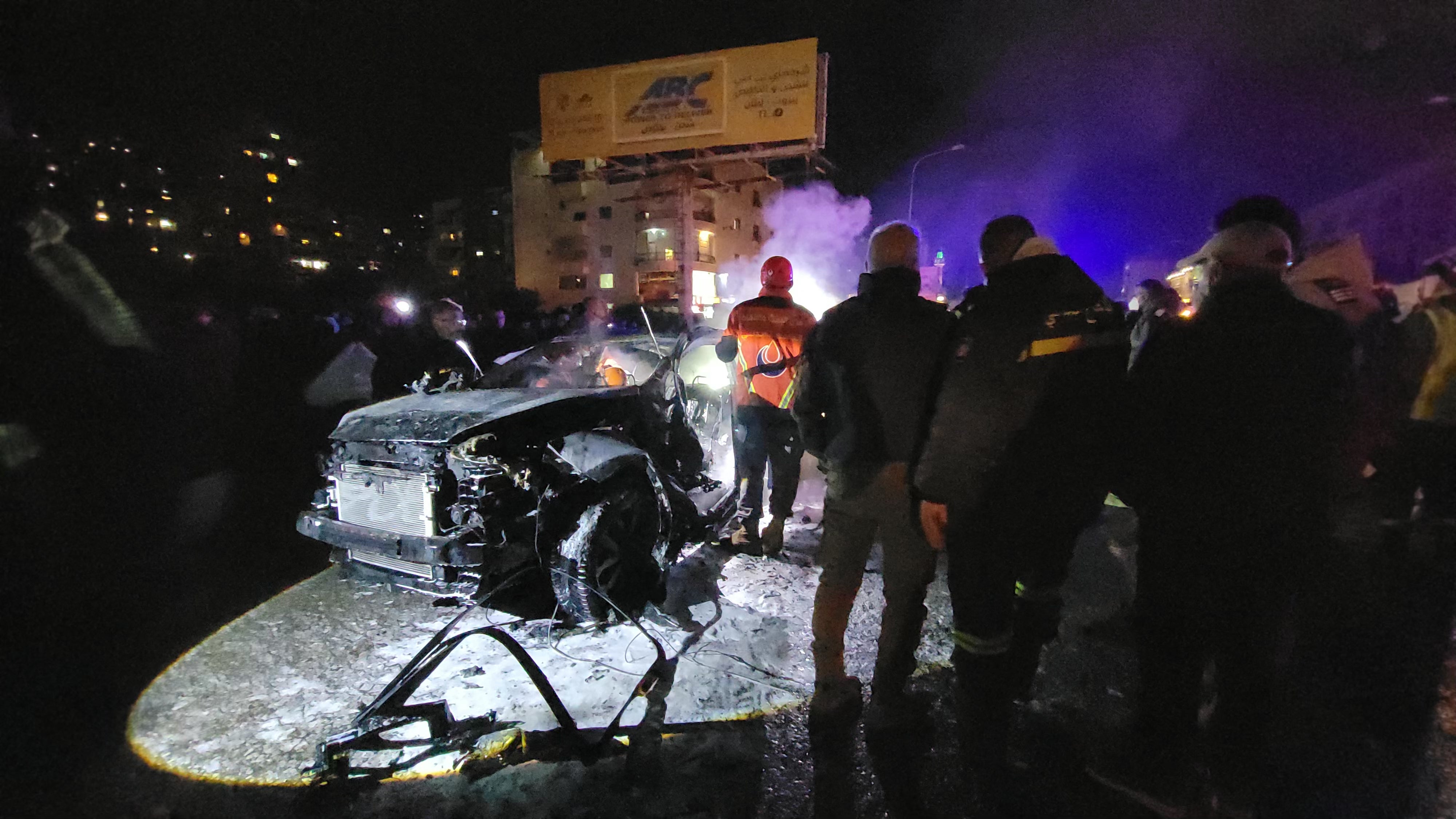 First responders gather near a vehicle targeted by an Israeli airstrike in the area of Khalde, south of Beirut, on April 1, 2026. (Photo by Fadel ITANI / AFP via Getty Images) /