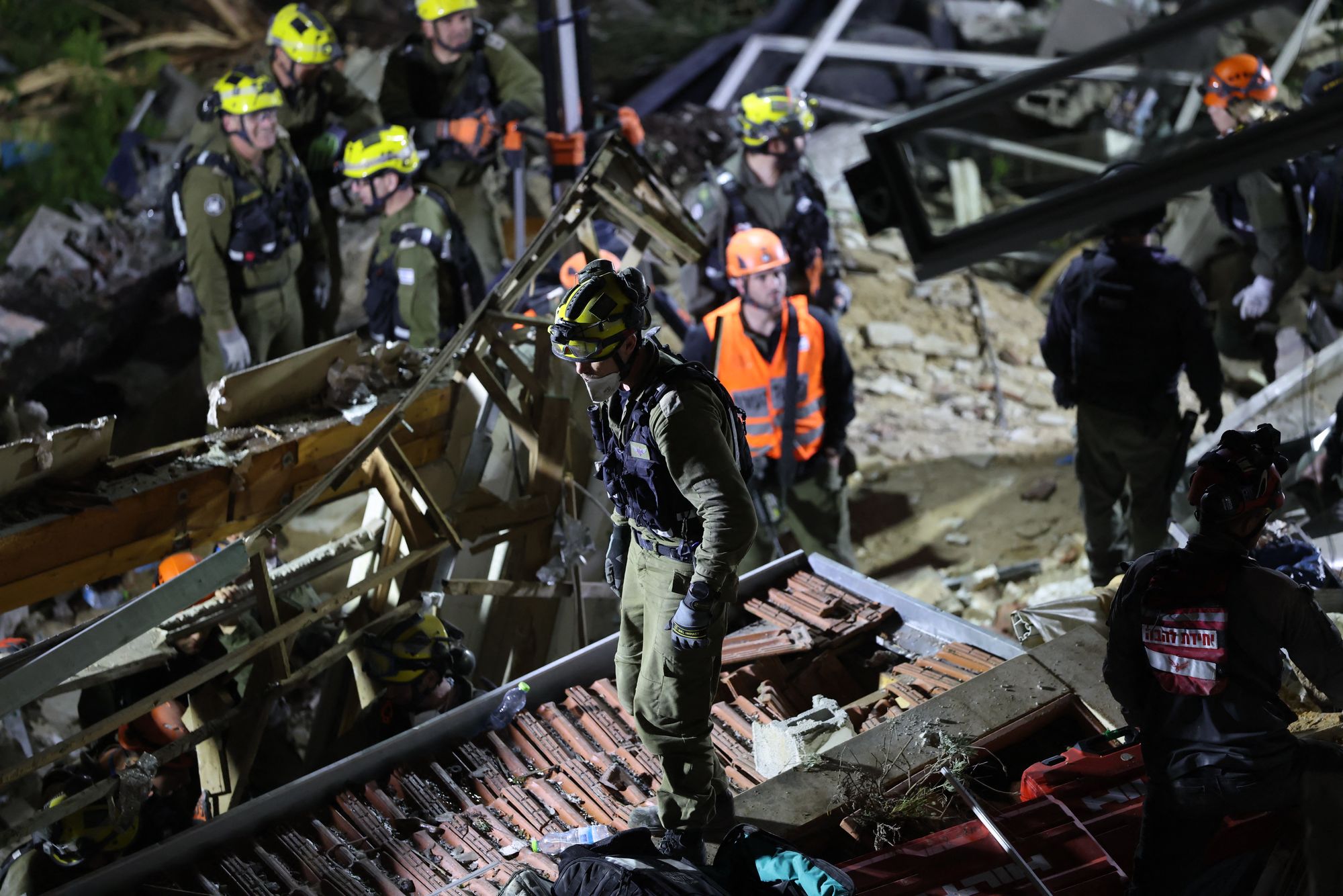 Israeli search and rescue personnel work at the site of a residential building destroyed in an Iranian strike in the northern city of Haifa on April 5, 2026