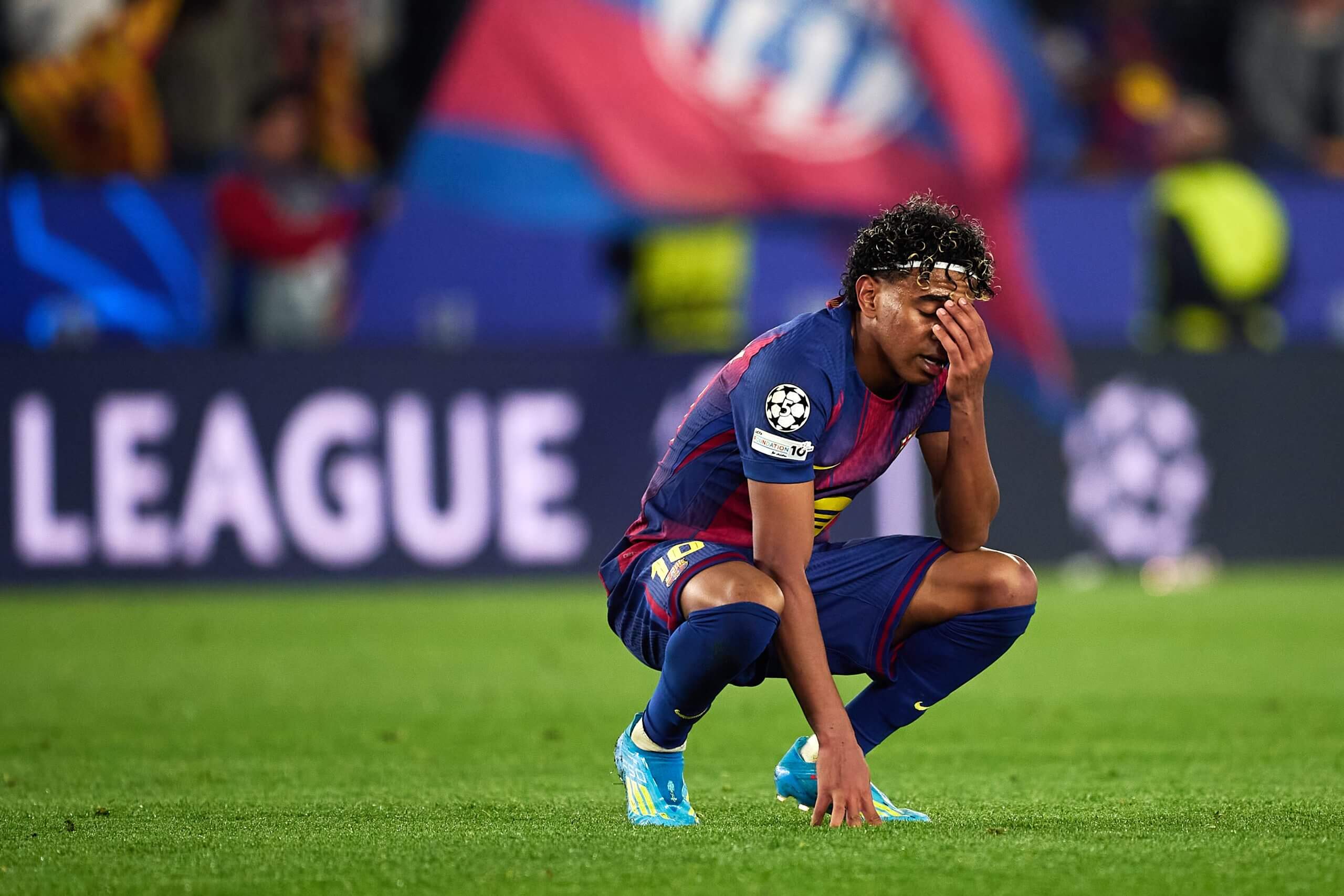 Barcelona's Lamine Yamal crouches and looks dejected following his side's 2-0 loss to Atletico Madrid
