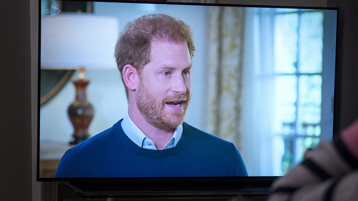 A person watching the Duke of Sussex interviewed by ITV's Tom Bradby on a television at home in Edinburgh