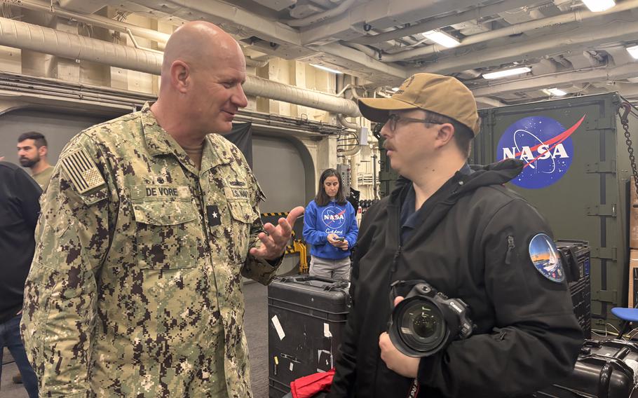 Charles Scudella III talks with a sailor.