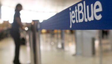 An attendant arranges the JetBlue check-in area at Logan International Airport in Boston.