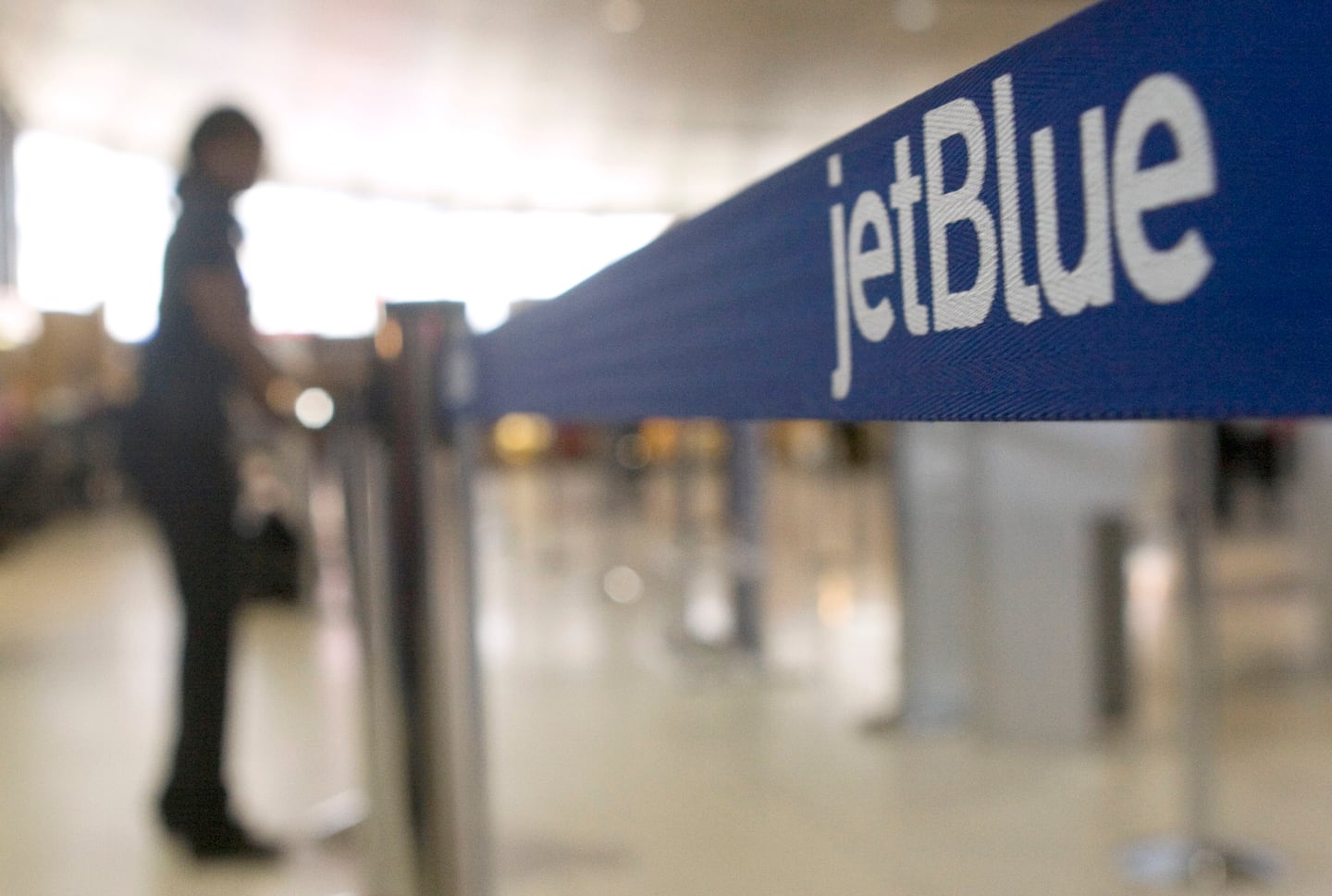 An attendant arranges the JetBlue check-in area at Logan International Airport in Boston.