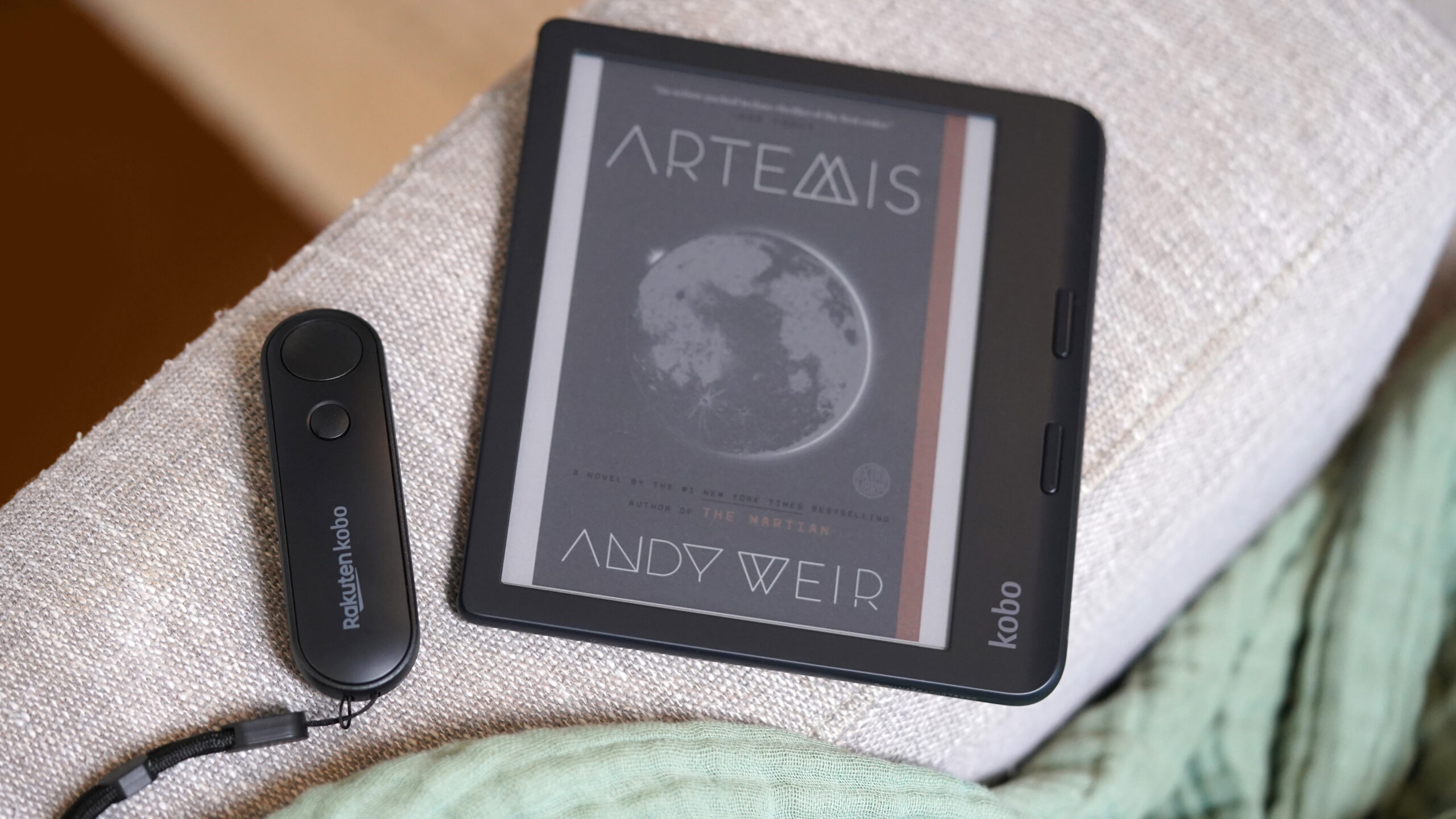 A Kobo Remote rets alongside a Kobo Libra Colour.