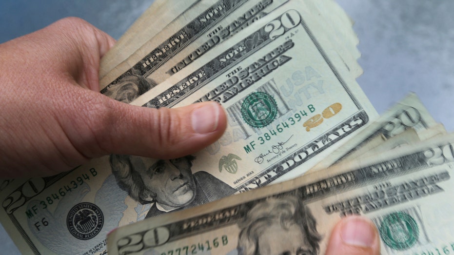 A person holding a stack of money