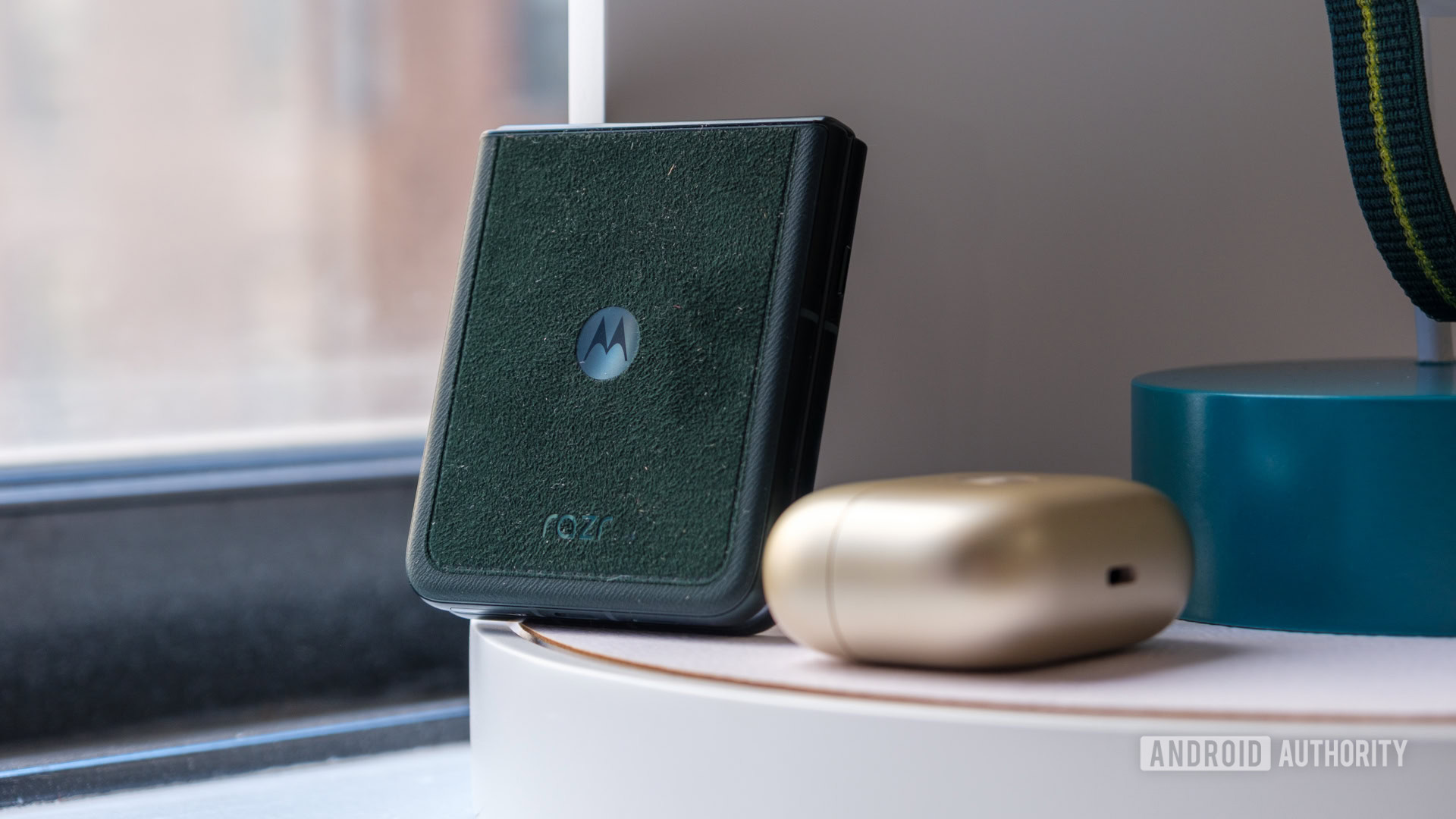 Motorola Razr Ultra in Alcantera next to Moto Loop Buds