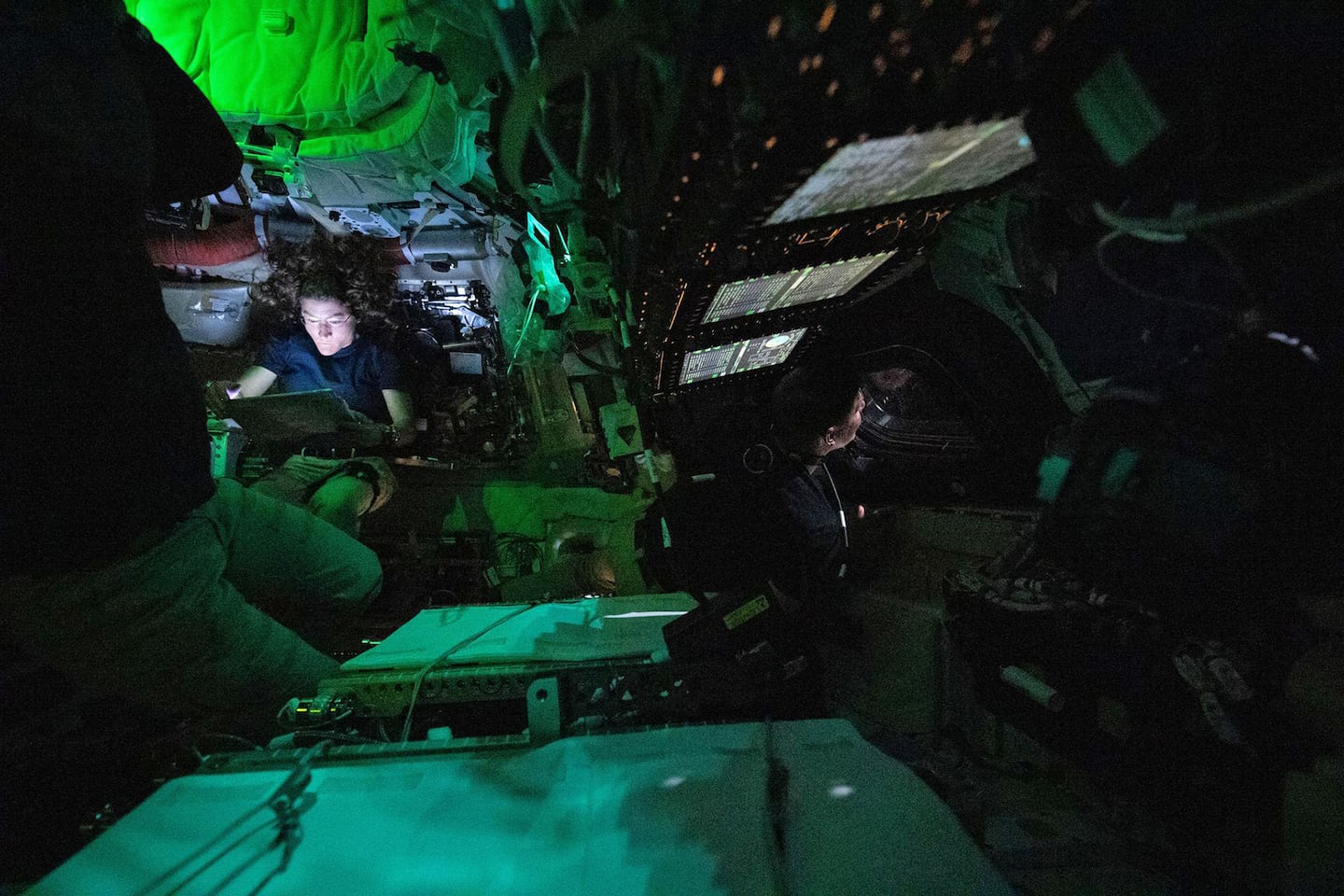 A photo provided by NASA shows astronaut Christina Koch illuminated by a screen inside the darkened Orion spacecraft on the third day of the agency's Artemis II mission, on April 3.