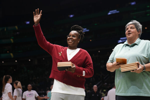 Former Seattle Storm player Epiphanny Prince, left, waves after being given a commemorative box by Storm co-owner Lisa Brummel, right, for being named to a list of top 25 players in franchise history before a WNBA basketball game between the Seattle Storm and the New York Liberty, Friday, Aug. 30, 2024, in Seattle. (AP Photo/Lindsey Wasson)