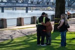 Family members grieve at the scene of the car crash into the Willamette River in Portland, Ore., on April 6, 2026. Their loved one, who Portland Police Bureau says is likely deceased, is the only victim from the crash still missing. The family, who chose to not share their names, expressed anger that the rescue mission was called off for the day due to river conditions.