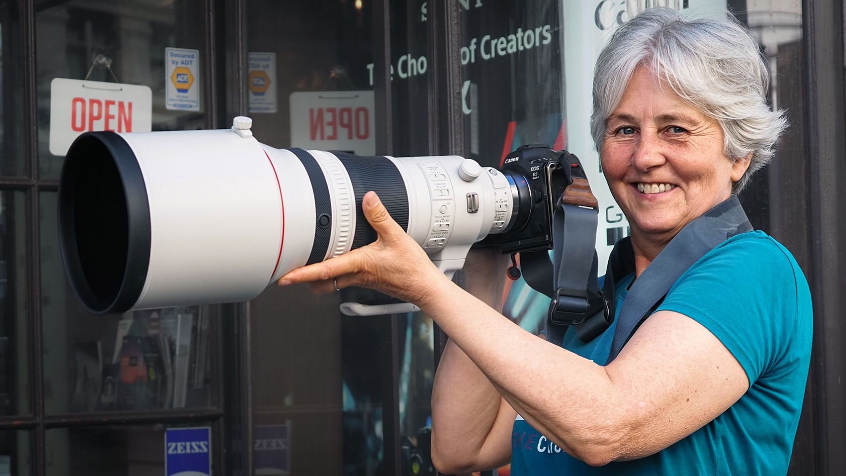 Smiling woman holding Canon RF 400mm f/2.8 lens