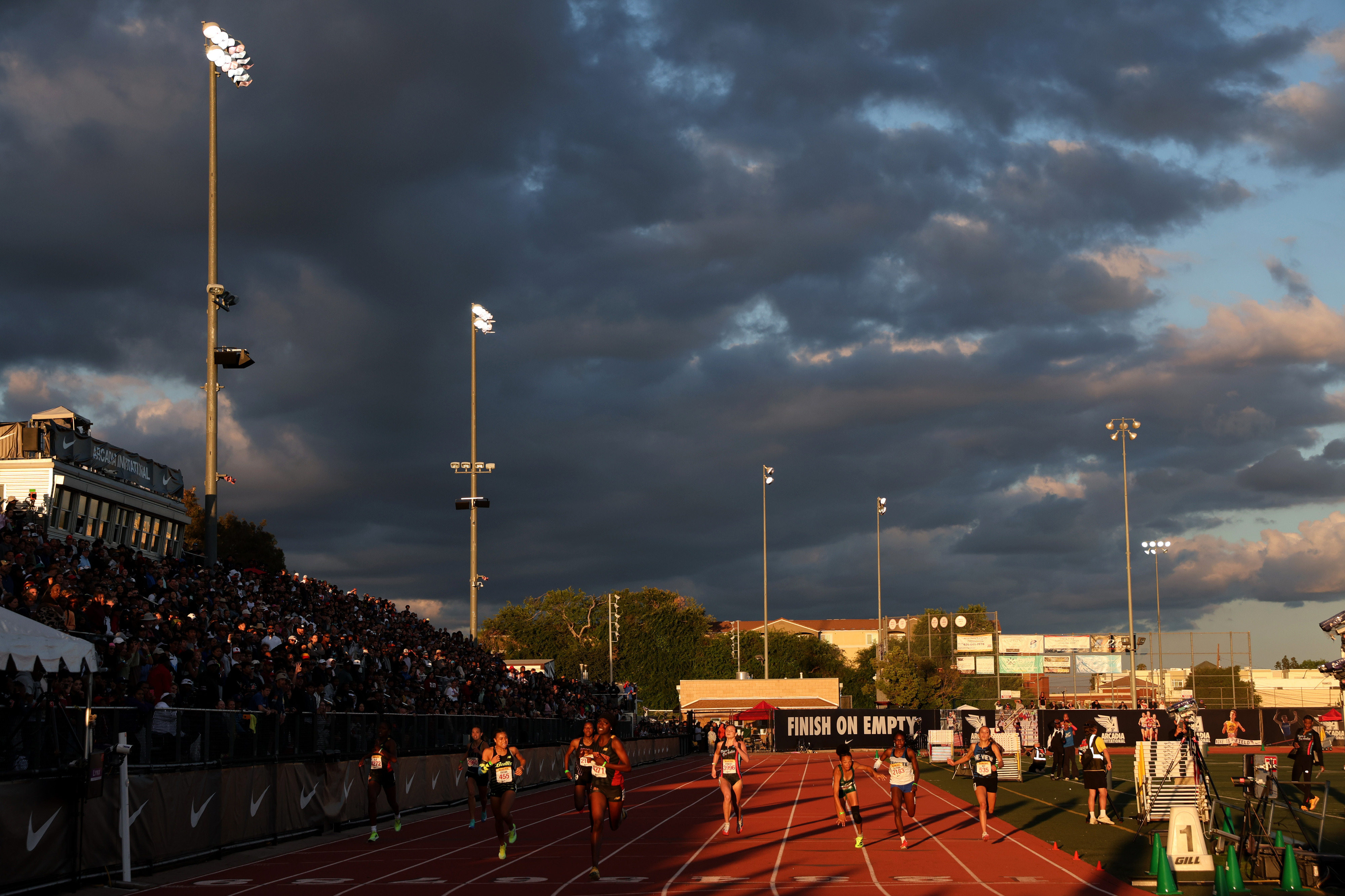 Runners compete in the girls 400 meter dash during the...