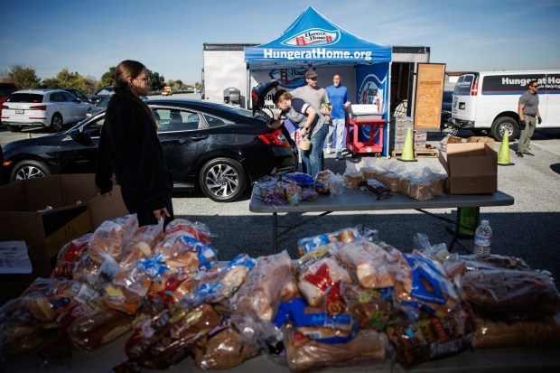 Volunteers put bags of food items into a clientÕs car during the weekly food distribution by the nonprofit Hunger at Home, held in the parking lot of the San Jose Flea Market in San Jose on Monday, Nov. 10, 2025. (Dai Sugano/Bay Area News Group)
