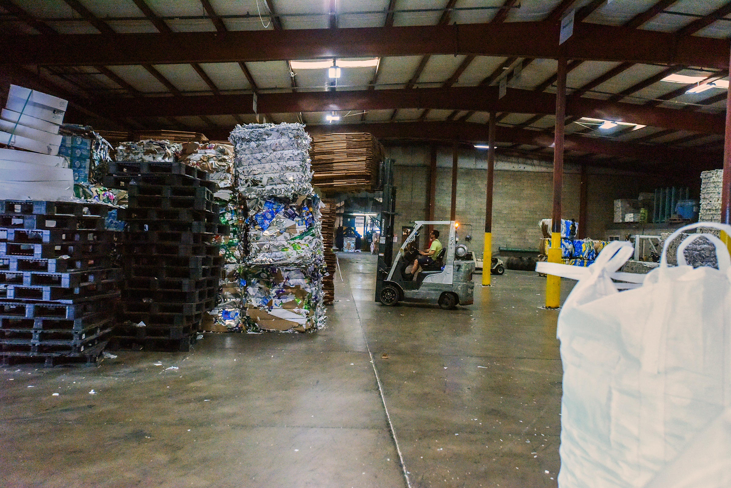 A forklift operator works in a warehouse on the grounds...