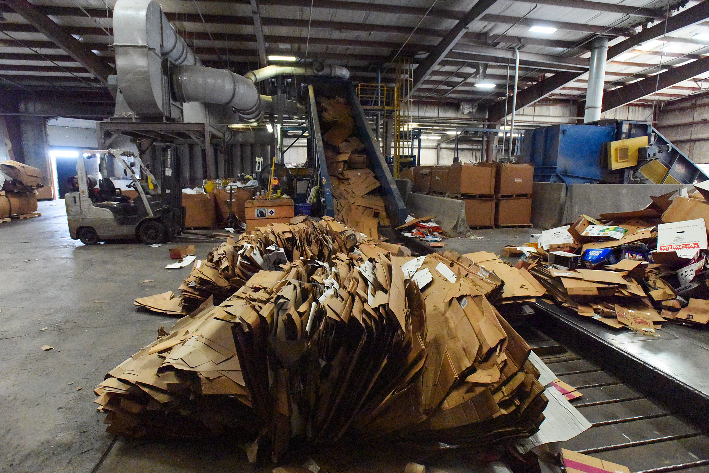 Cardboard sits at the end of a baler at Diamond...