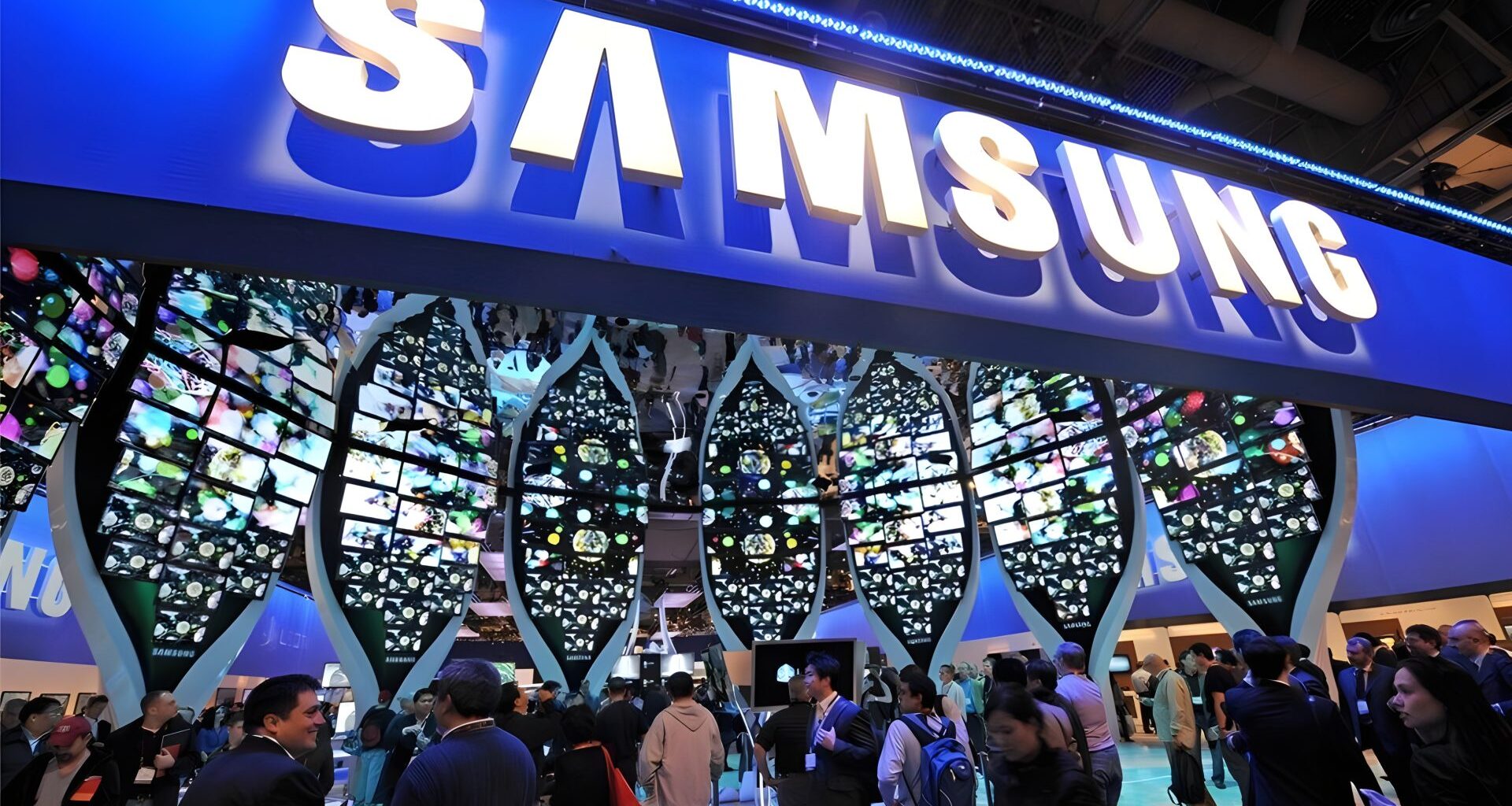 Visitors gather around a Samsung booth with large, leaf-shaped digital displays showcasing vibrant images at a tech convention.