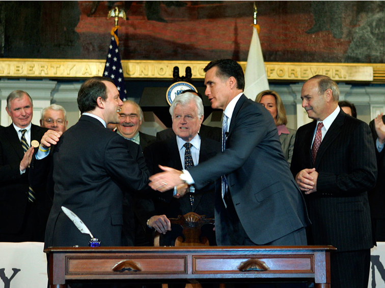 After signing Massachusetts' universal health care coverage law on April 12, 2006, then-Gov. Mitt Romney shakes hands with state Health and Human Services Secretary Timothy Murphy as Sen. Edward Kennedy and others look on at Faneuil Hall in Boston. (AP)