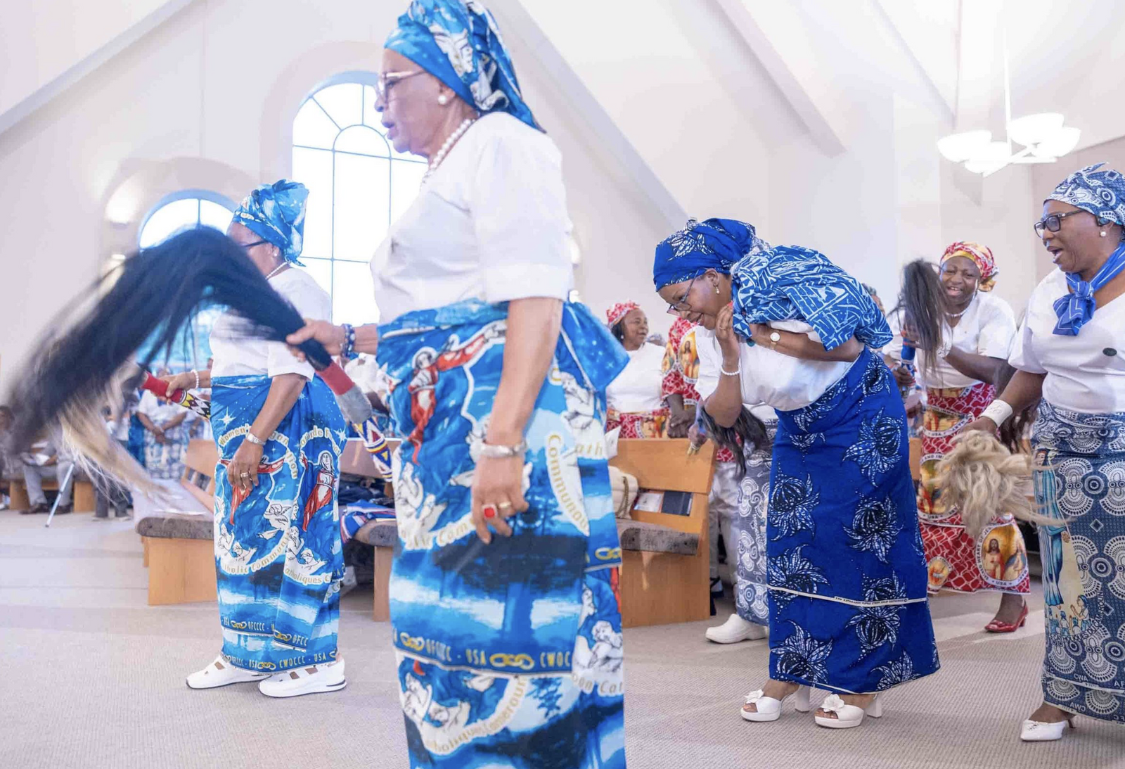 Women wearing traditional African dress process to the sanctuary during a Mass of Thanksgiving at St. Joseph Catholic Church in Beltsville, Maryland, on April 17, 2026 that commemorated the 70th birthday of Bishop Jerome Feudjio of the Diocese of St. Thomas in the U.S. Virgin Islands and his fifth anniversary leading that diocese. They presented the lectionary to the bishop, who held it aloft. (Catholic Standard photos by Mihoko Owada)