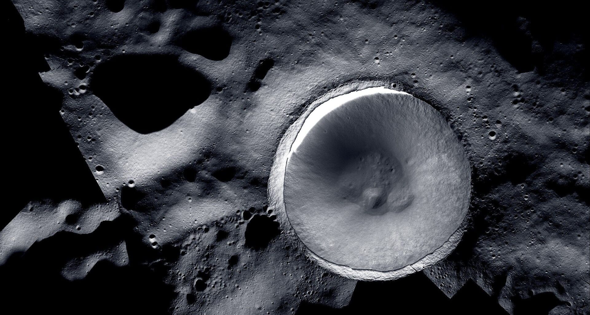 a large crater on the grey, cratered surface of the moon