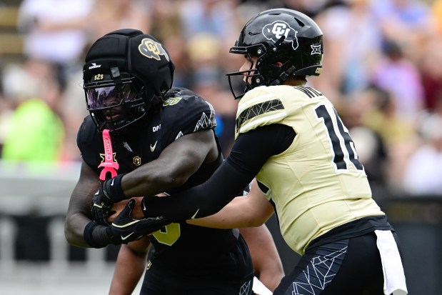 Colorado Buffaloes' Richard Young, left, takes the handoff from quarterback Isaac Wilson, right, during the Black and Gold spring football game at Folsom Field in Boulder on Saturday, April 11, 2026. (Matthew Jonas/Staff Photographer)