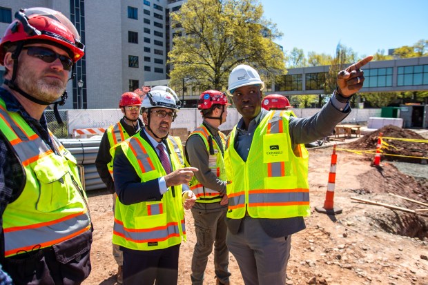 Jeffrey A. Flaks, president and CEO of Hartford HealthCare, talks with Keith Grant, vice president of operations, during a tour of construction with contractors from Consigli Construction at the new parking garage site at the Hartford campus.(Aaron Flaum/Hartford Courant)