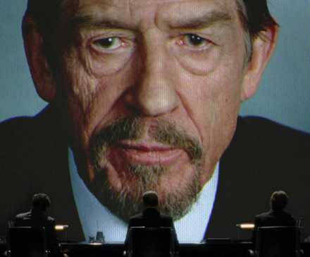 Adam Suttler (John Hurt) speaking from a large video screen in V for Vendetta.