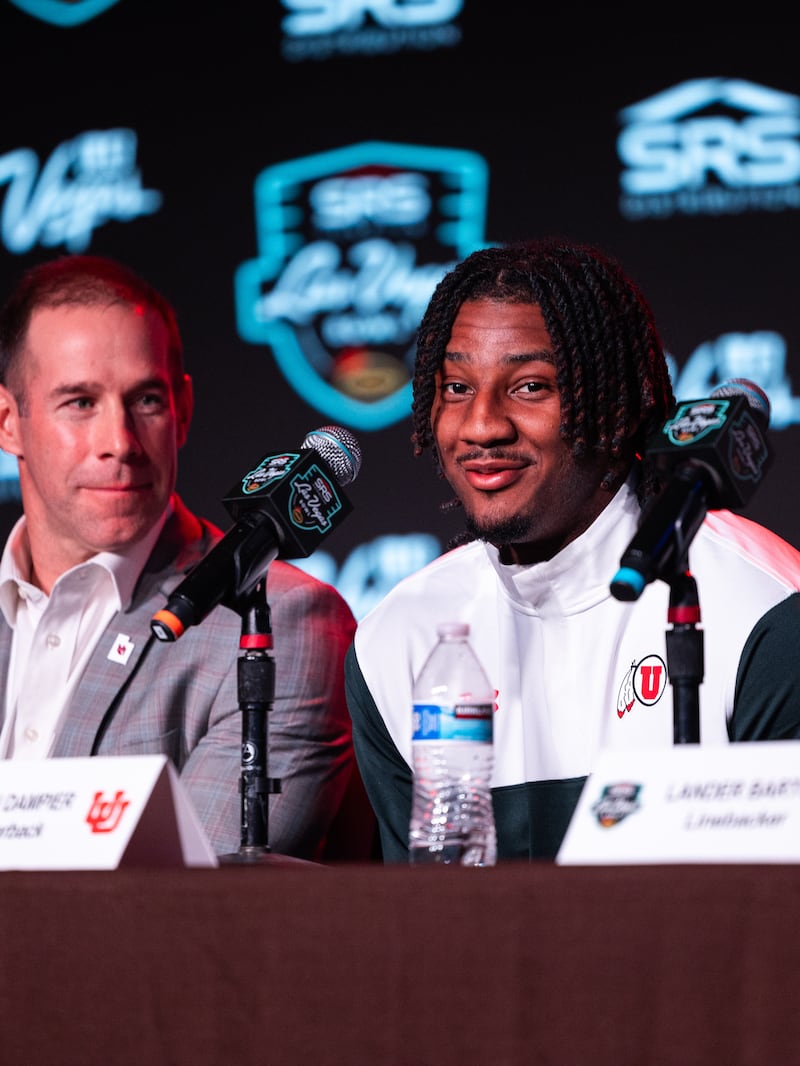 New Utah head coach Morgan Scalley, left, looks on as quarterback Devon Dampier fields a question at the Las Vegas Bowl press conference Tuesday in Las Vegas.
