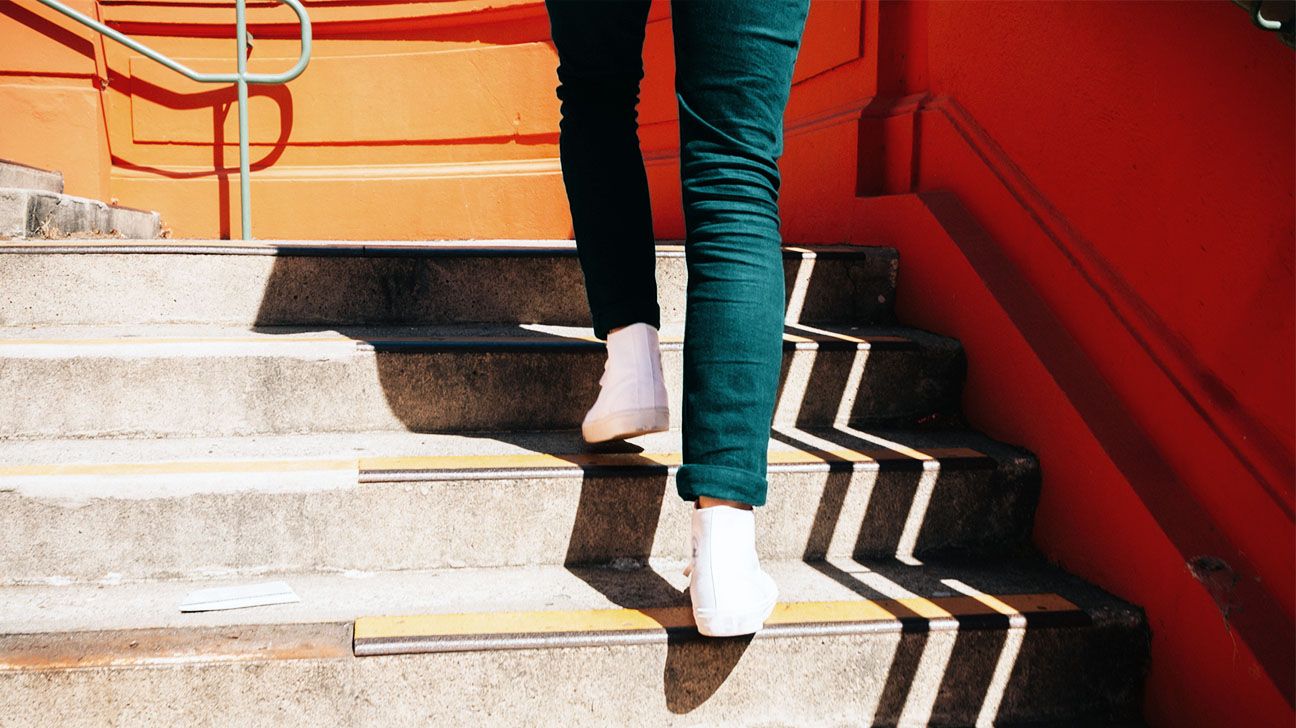 Image of a person's feet walking up stairs outside