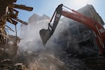 FILE - An excavator removes rubble at the site of a strike that, according to a security official at the scene, destroyed half of the Khorasaniha Synagogue and nearby residential buildings in Tehran, Iran, Tuesday, April 7, 2026.