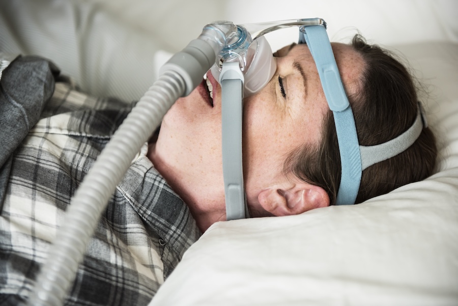 a woman sleeping with anti snoring chin strap 2026 01 07 23 56 45 utc