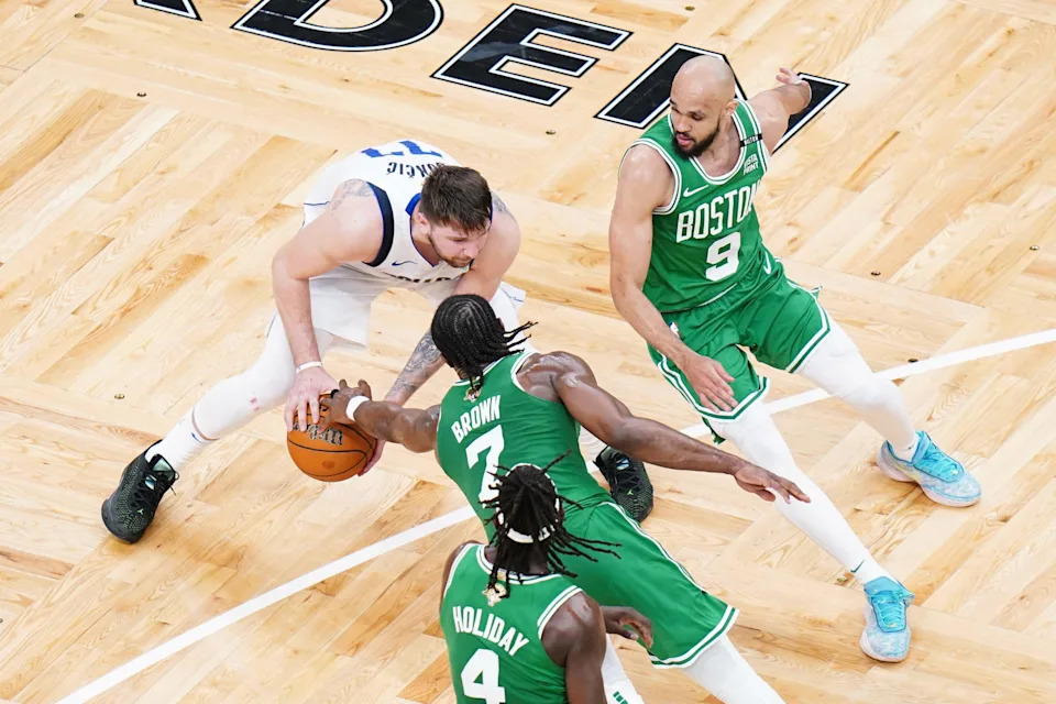 Jun 17, 2024; Boston, Massachusetts, USA; Dallas Mavericks guard Luka Doncic (77) controls the ball against Boston Celtics guard Jaylen Brown (7) and guard Derrick White (9) in the second quarter during game five of the 2024 NBA Finals at TD Garden. Mandatory Credit: David Butler II-USA TODAY Sports