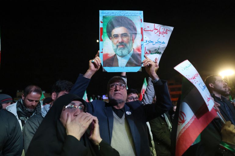 An Iranian man holds up picture of Iranian supreme leader Ayatollah Mojataba Khamenei as others react to a ceasefire announcement at the Enqelab square, in Tehran, on April 8 2026.