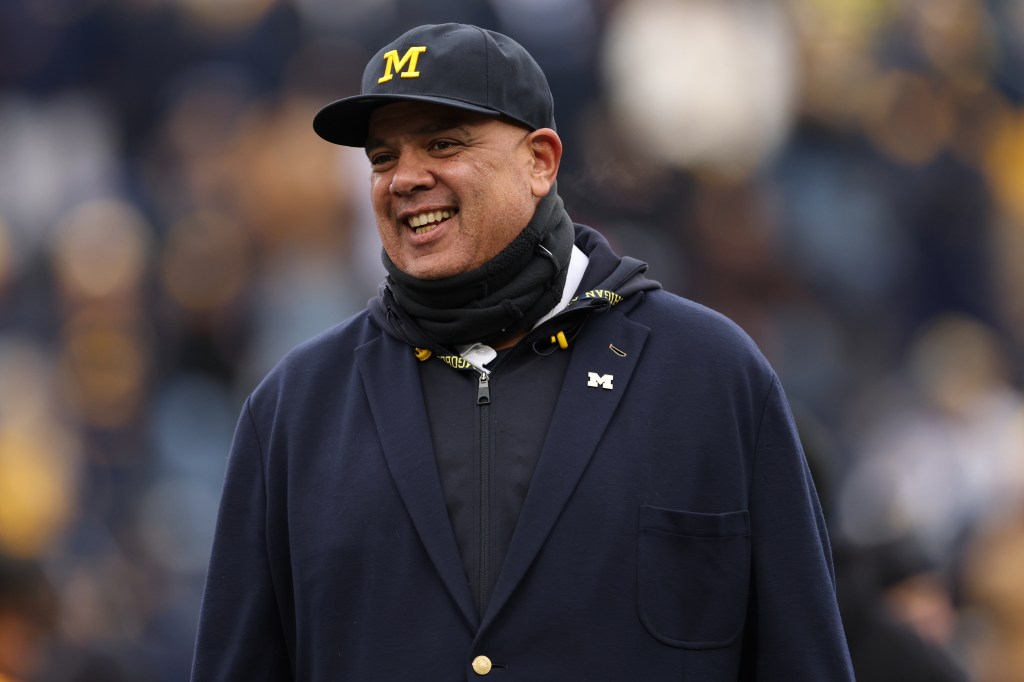 Michigan Wolverines athletic director Warde Manuel smiles on the field.