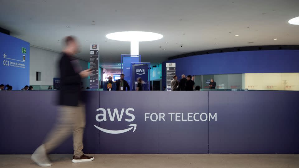 A visitor walks past the logo of Amazon Web Services AWS during the Mobile World Congress (MWC), the world's biggest mobile technology showcase and fair in Barcelona, Spain, on March 2, 2026. - Manaure Quintero/AFP/Getty Images