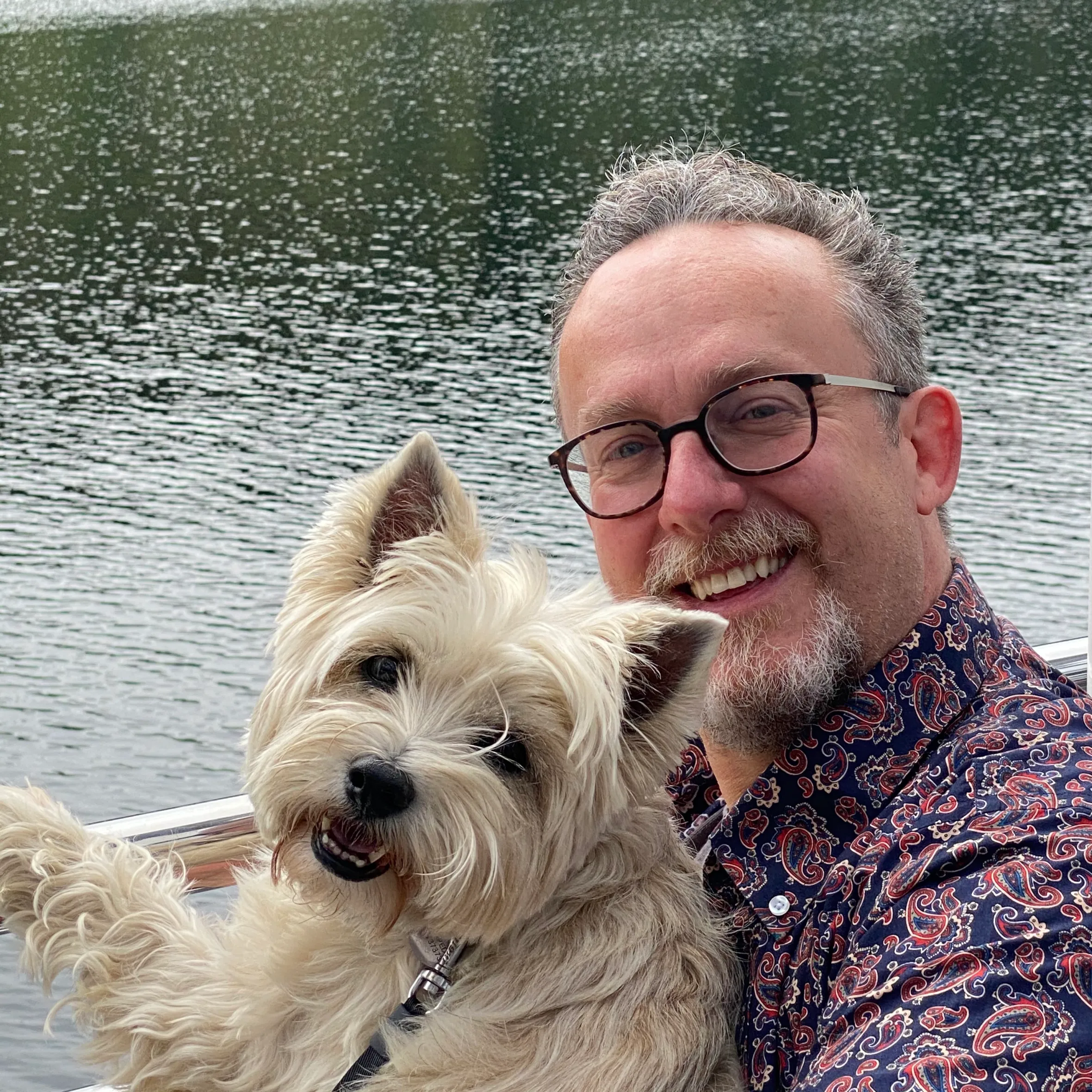 Rob Briggs, an award-winning communications specialist, with his dog on a boat.