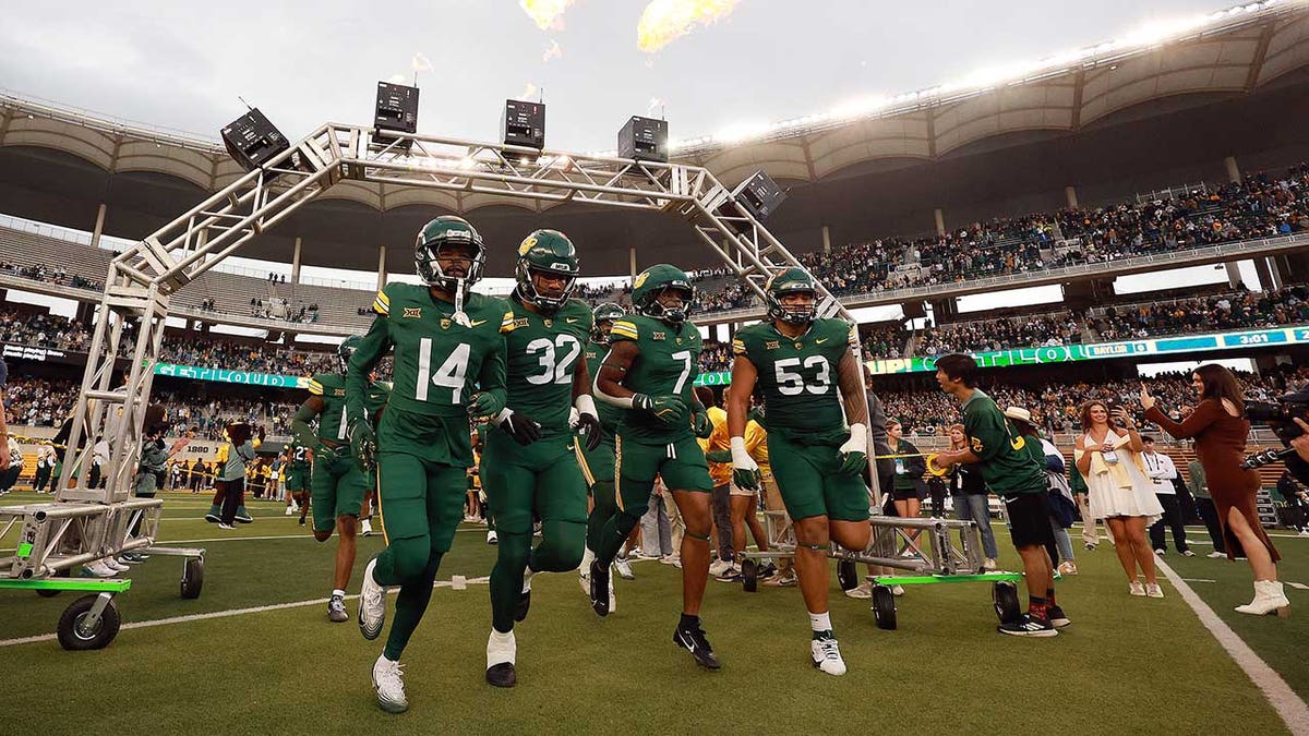 Baylor Bears football players running onto the field at McLane Stadium in Waco, Texas