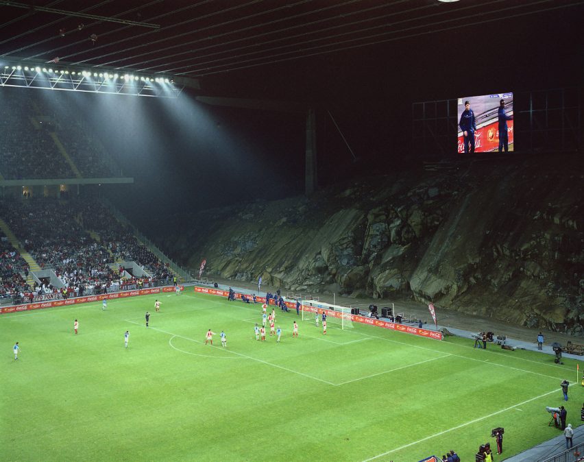 Night-time match at Braga Municipal Stadium with the exposed quarry wall forming the backdrop