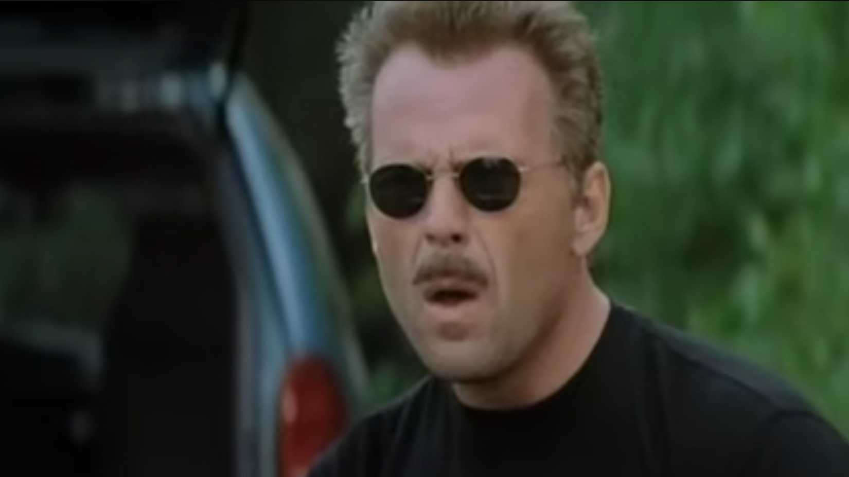 Bruce Willis as the Jackal wearing sunglasses at a shooting range