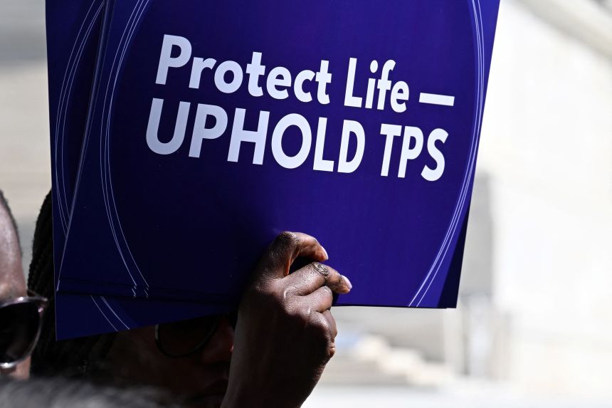 A protester holds a sign calling on the US Supreme Court to uphold Temporary Protected Status (TPS) for Haitian refugees in front of the court in Washington, DC, on March 16.