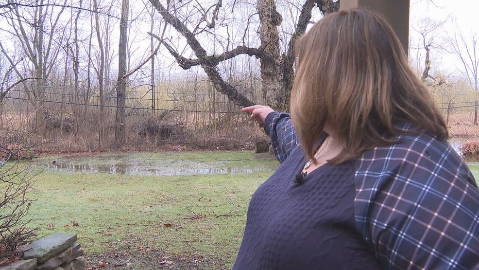Andrea Butler points to flooding in her backyard in Greece, Wednesday, April 1, 2026. (Photo by Julia Coburn/WHAM)