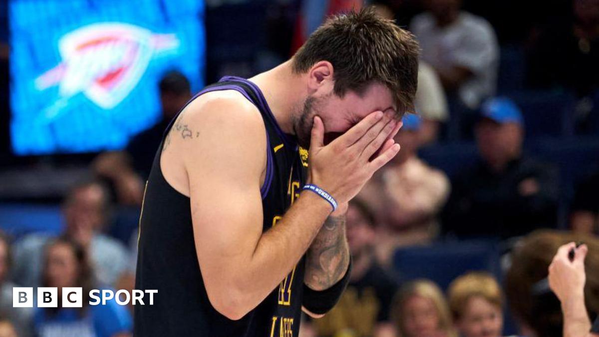 LA Lakers star Luka Doncic covers his face with his hands as he walks off the court after suffering an injury