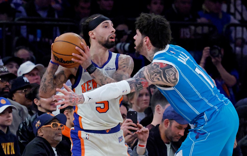 New York Knicks guard Jose Alvarado defends against Charlotte Hornets guard LaMelo Ball during a game.