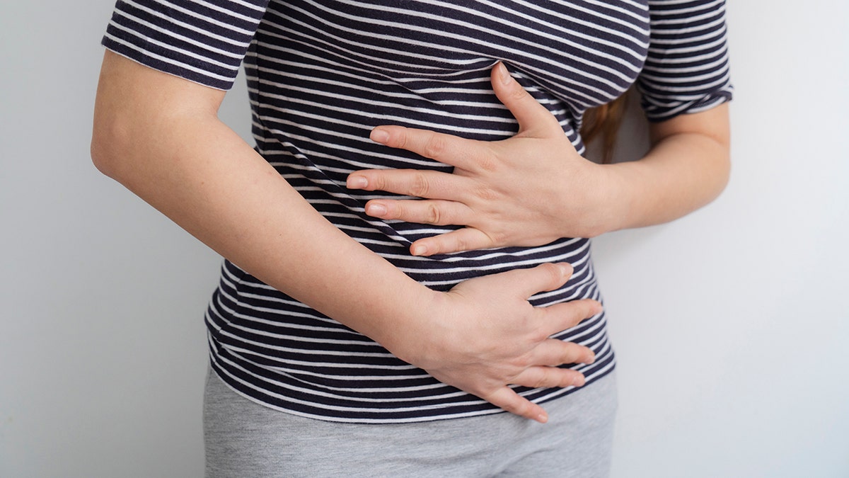 Woman holding abdomen appearing to have menstrual pain