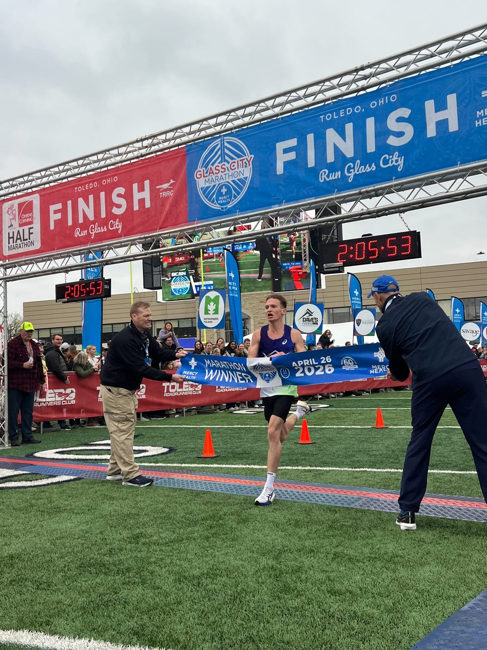 Runner crossing the finish line at a marathon event.