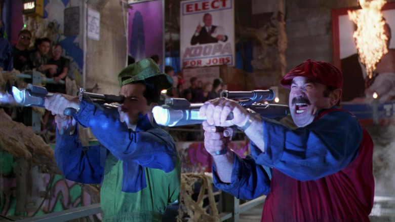 John Leguizamo as Luigi and Bob Hoskins as Mario brandish bazooka-like weapons in Super Mario Bros.