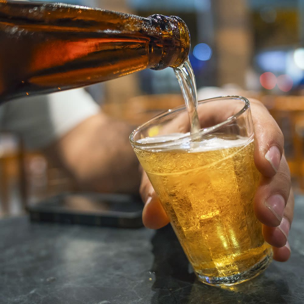 a man pours beer into a glass in a brazilian bar