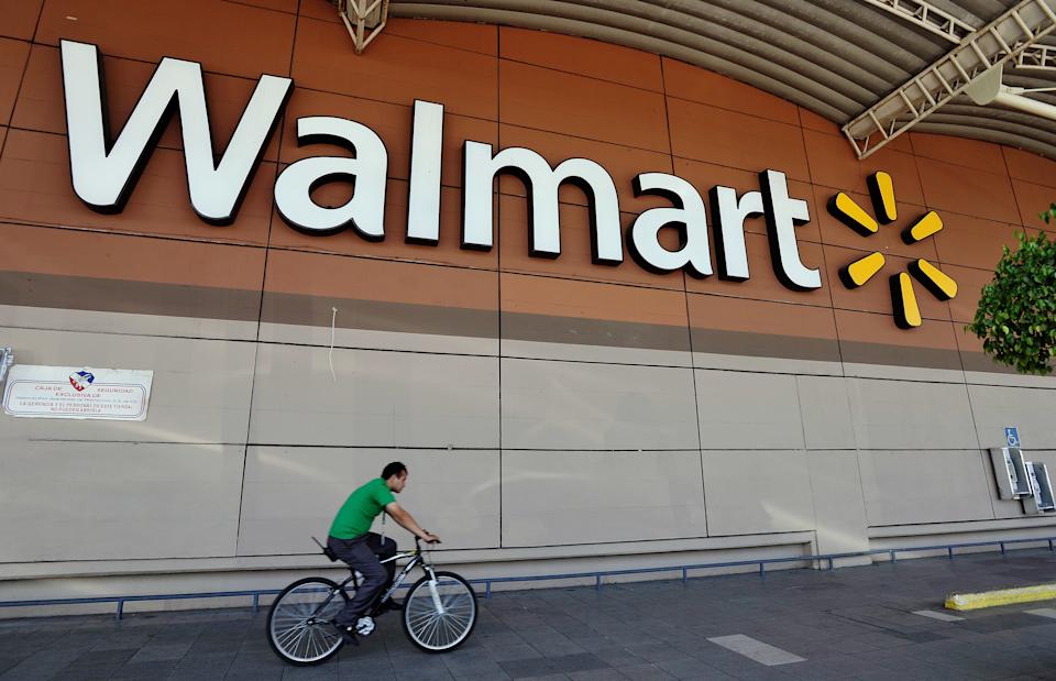 MEXICO CITY, MEXICO - APRIL 23:  A man rides his bike past Wal-Mart store signage on April 23, 2012 in Mexico City, Mexico. According to reports, Wal-Mart de Mexico orchestrated a campaign of bribery to win market dominance by paying bribes to obtain permits in parts of the country. Wal-Mart Inc, along with two U.S. congressmen is conducting internal investigations over the allegations.  (Photo by Daniel Aguilar/Getty Images)