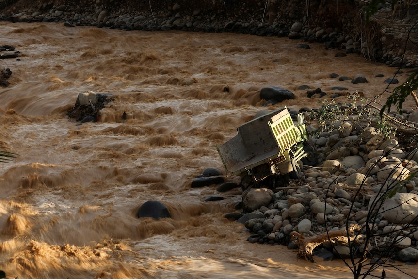 A truck balances on its side amid intense flash flooding.