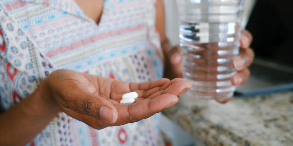 Woman Holds Pills in Palm of Hand