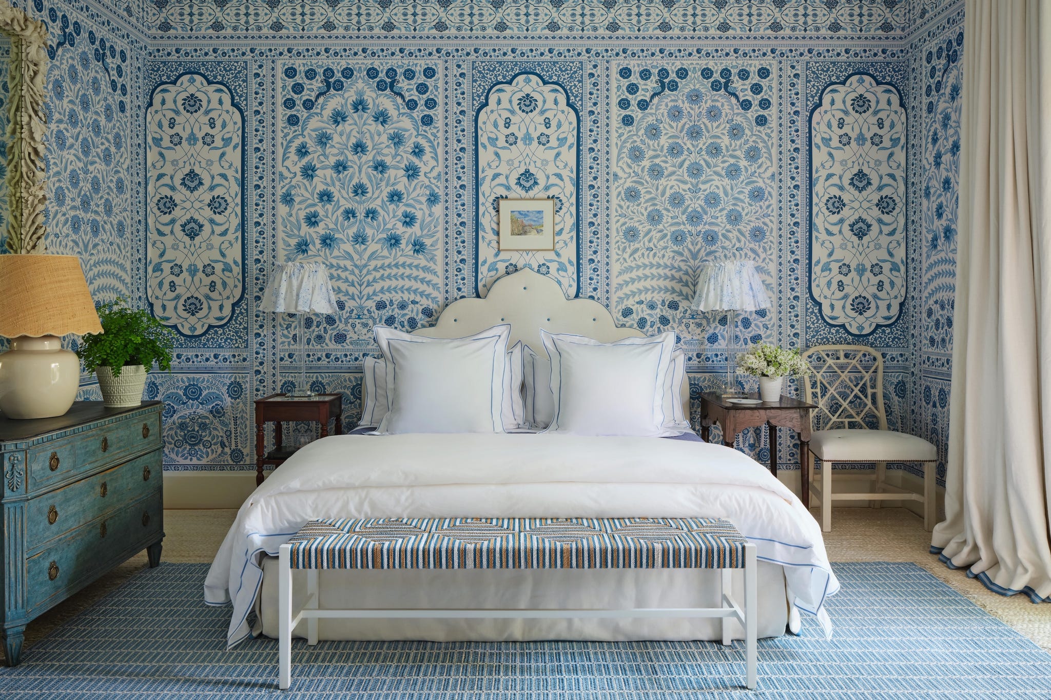 Decorative bedroom with blue and white wallpaper and furniture.